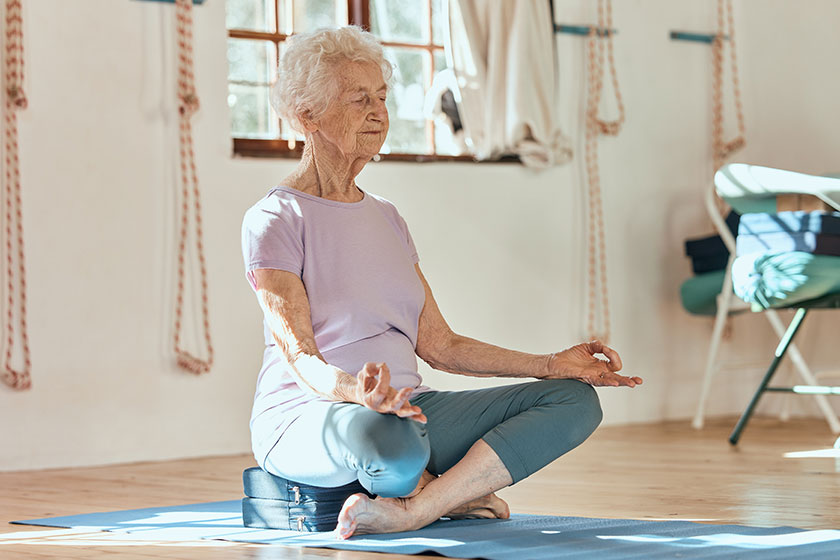 elderly woman yoga meditation wellness while sitting floor home gym elderly woman yoga meditation wellness while sitting floor home gym