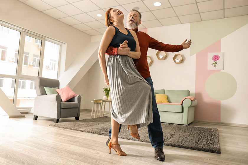 Happy mature couple dancing home
