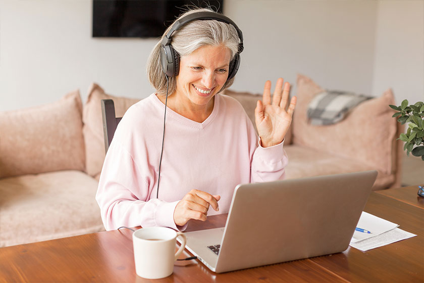 Happy middle aged online course student headphones learning watching webinar