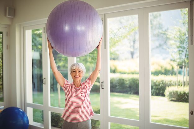 portrait senior woman exercising fitness ball