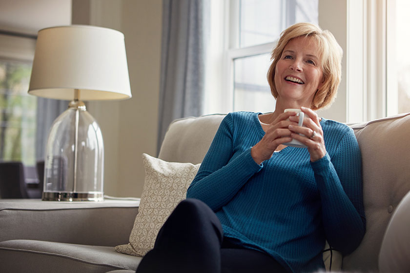 Retire smile happy mature woman relaxing sofa warm beverage home Retire smile happy mature woman relaxing sofa warm beverage home