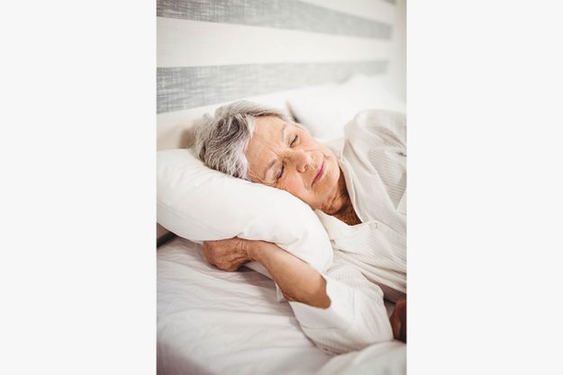 Senior woman sleeping on bed