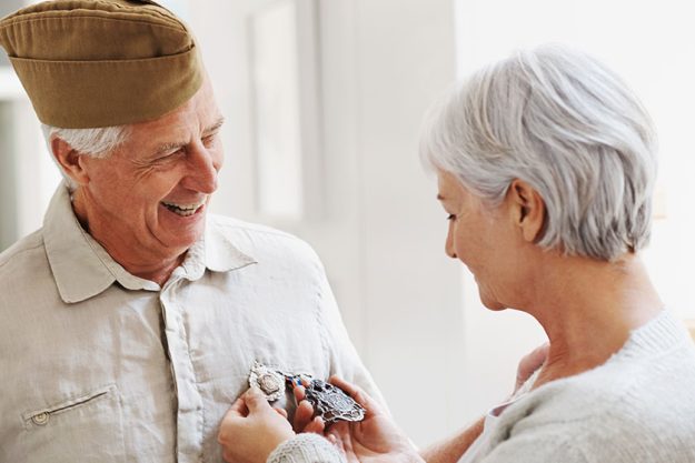 proud war veteran husband senior woman looking her husbands medals