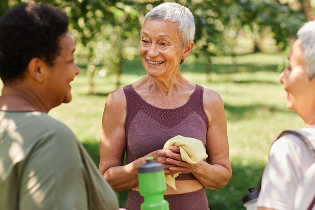waist portrait smiling senior woman chatting friends outdoor workout park waist portrait smiling senior woman chatting friends outdoor workout park