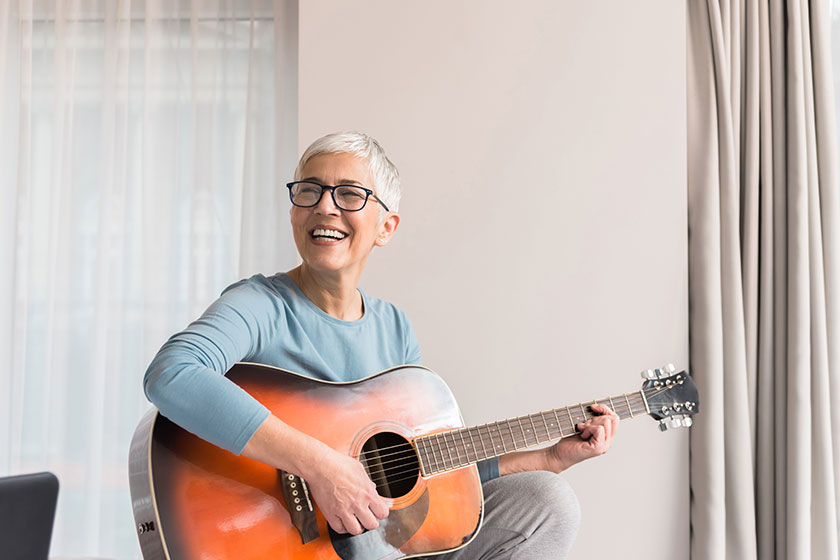 cheerful charming beautiful mature woman enjoy playing guitar musical hobbies