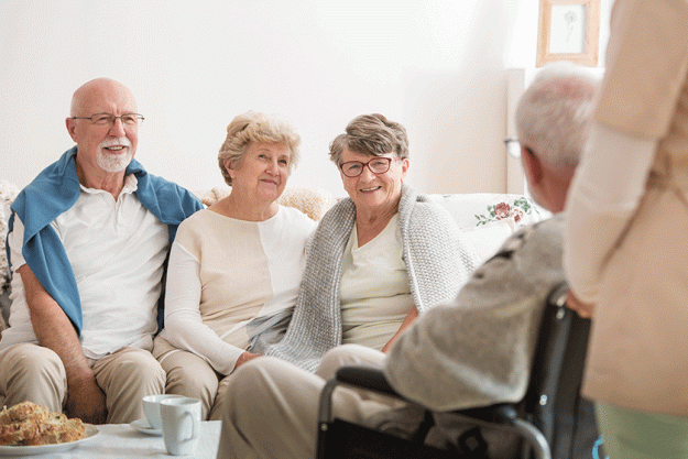 group of senior friends sitting together in common living room of nursing home group of senior friends sitting together in common living room of nursing home