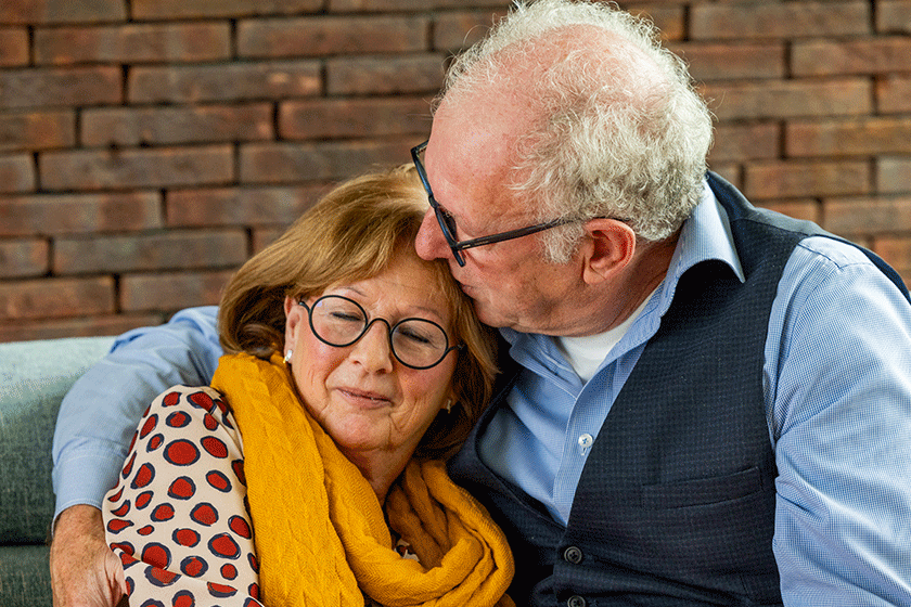 intimate scene elderly man grey hair glasses depicted giving tender