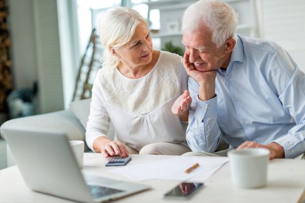 older couple reading papers together sofa