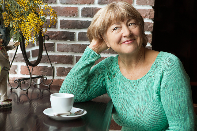 portrait of senior woman in smart clothes having tea in cafe