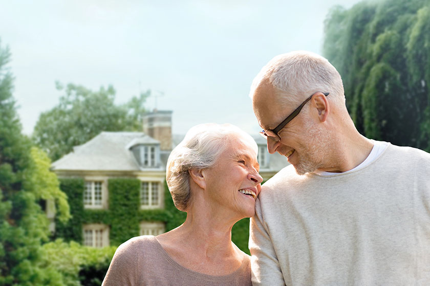 Senior couple hugging over living house background