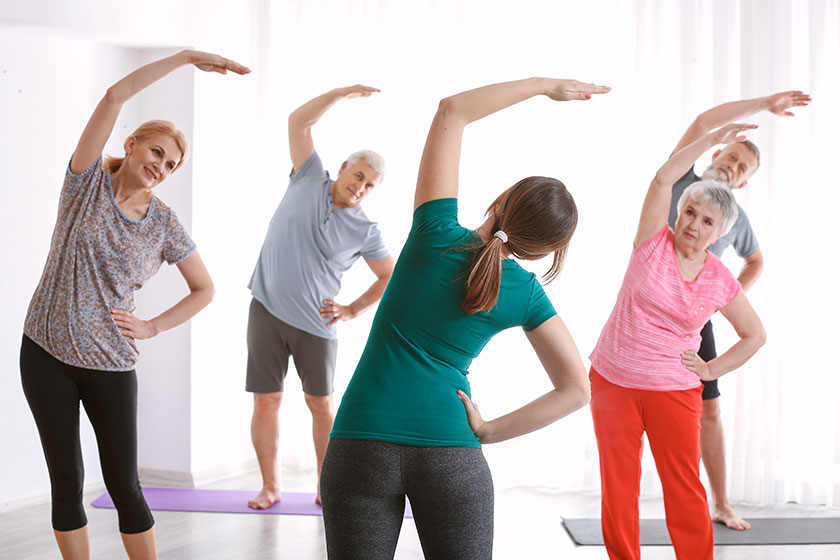 senior people with young trainer doing exercises in nursing home senior people with young trainer doing exercises in nursing home