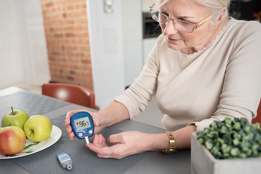 senior woman checking blood sugar level at home