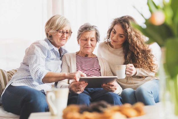 a teenage girl mother and grandmother with tablet at home