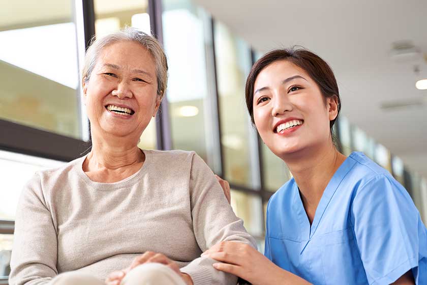 asian senior woman her caregiver looking camera smiling