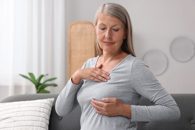 beautiful senior woman doing breast self examination
