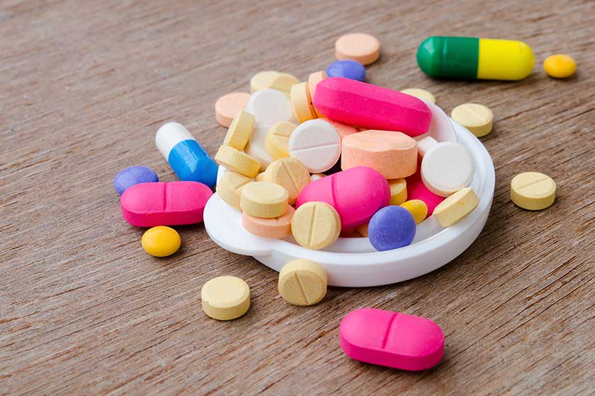close up colorful medicine capsule pill on wood background