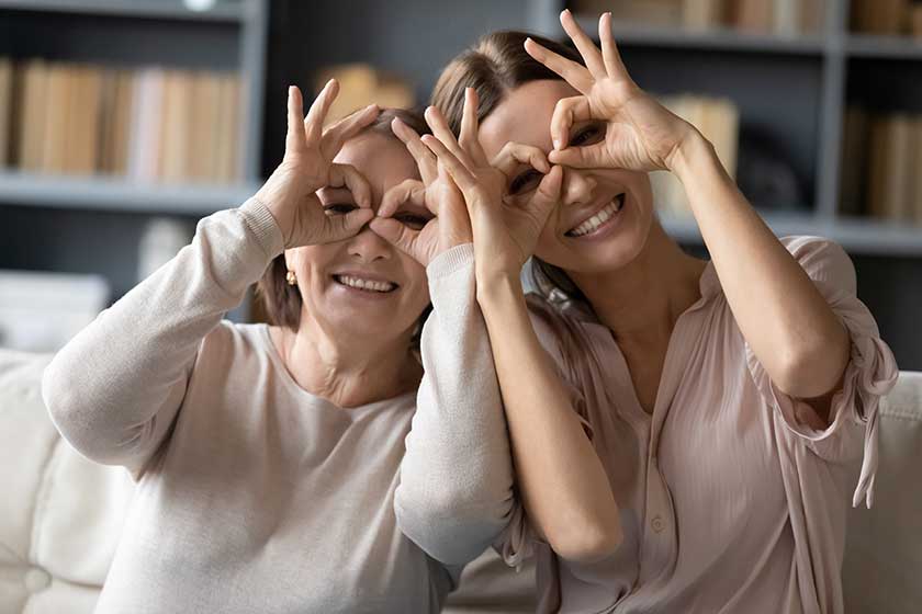 excited adult mother and daughter make funny gestures posing