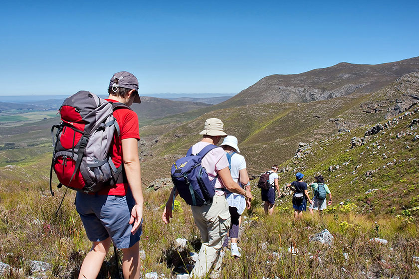 group of female hikers walks downhill