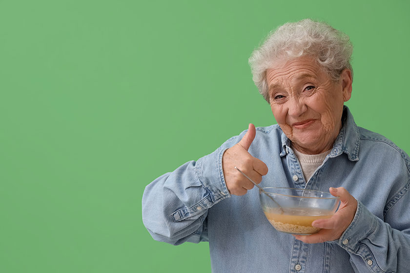 ill senior woman eating soup green background ill senior woman eating soup green background