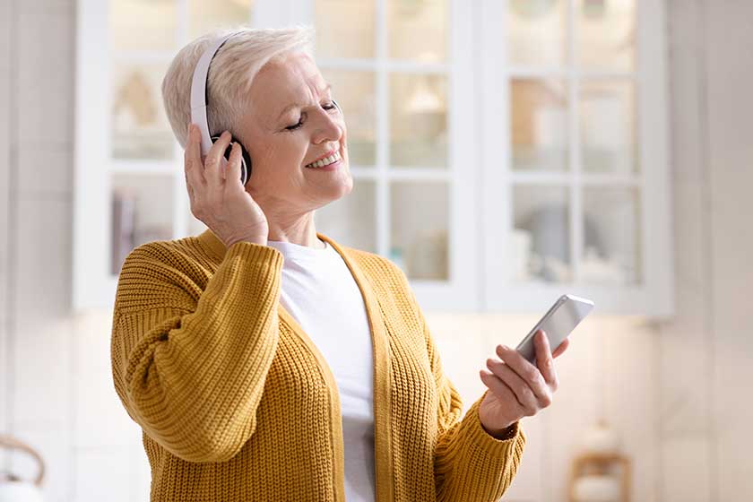 joyful grandmother having fun listening to music on phone joyful grandmother having fun listening to music on phone