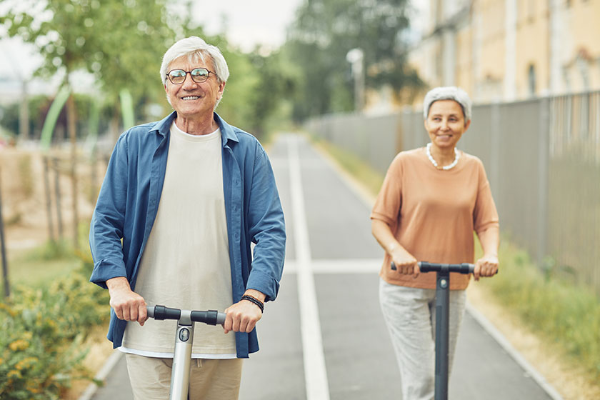 Mature couple riding electric scooters