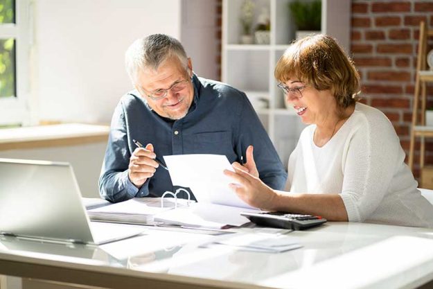 portrait happy senior couple reading letter together