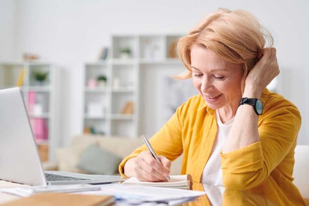 pretty blond businesswoman casualwear planning work making notes while working