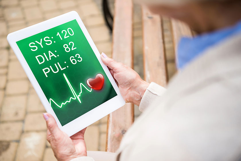 selective focus senior woman using digital table heartbeat rate screen