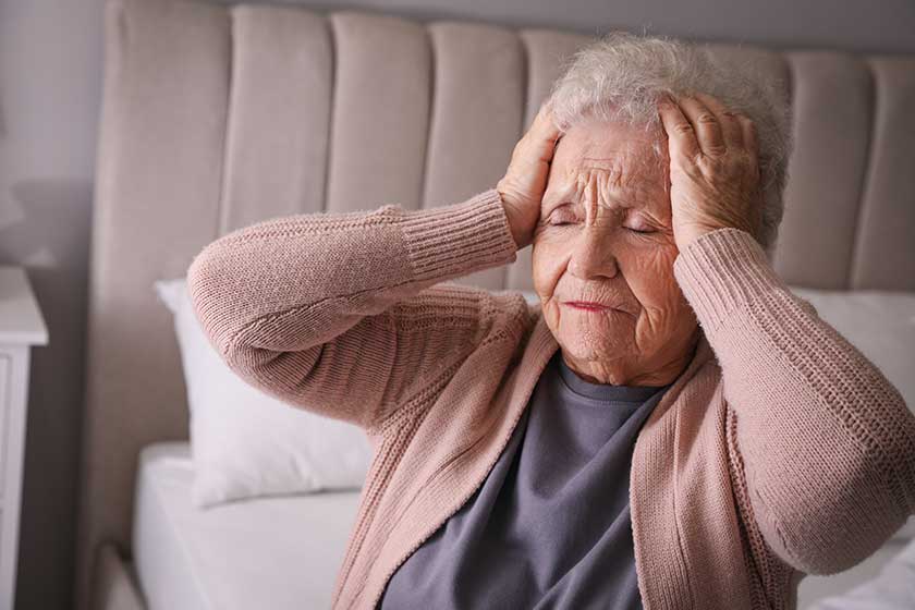 senior woman headache bedroom home