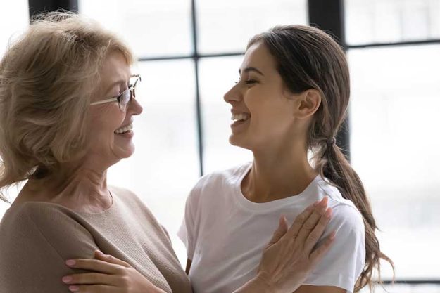 smiling elderly mom and adult daughter have fun