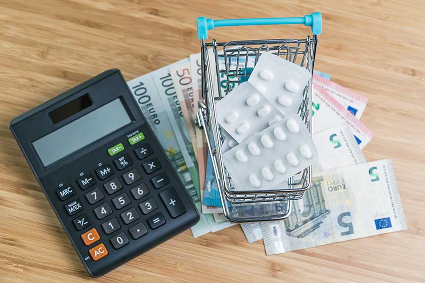 white package pills miniature shopping cart pile euro banknotes money