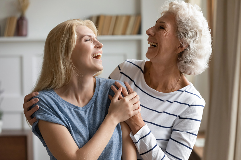 cheerful mature mother and grownup daughter laughing