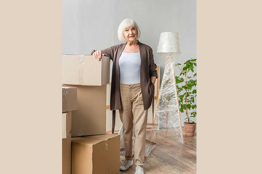 full length view senior woman leaning boxes moving concept full length view senior woman leaning boxes moving concept