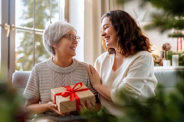 merry christmas happy holidays senior mom her adult daughter exchanging