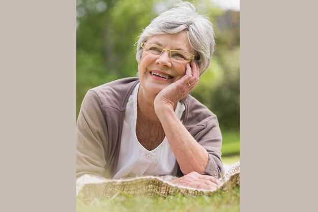 smiling senior woman lying at park