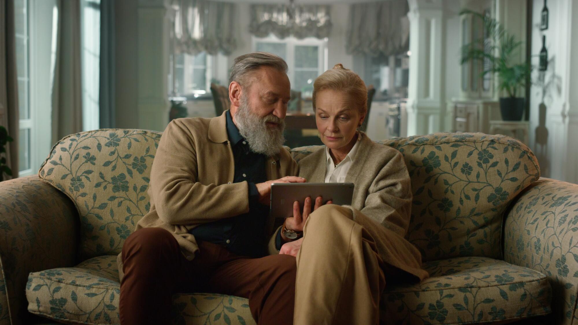 Elegant,Senior,Couple,Surfing,Internet,On,Tablet,In,Luxury,Living
