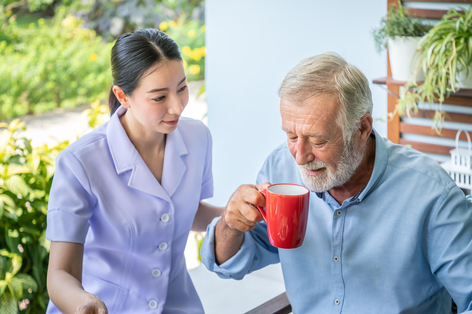 Nurse,Assist,Elderly,Senior,Man,To,Drink,Coffee,With,Mug