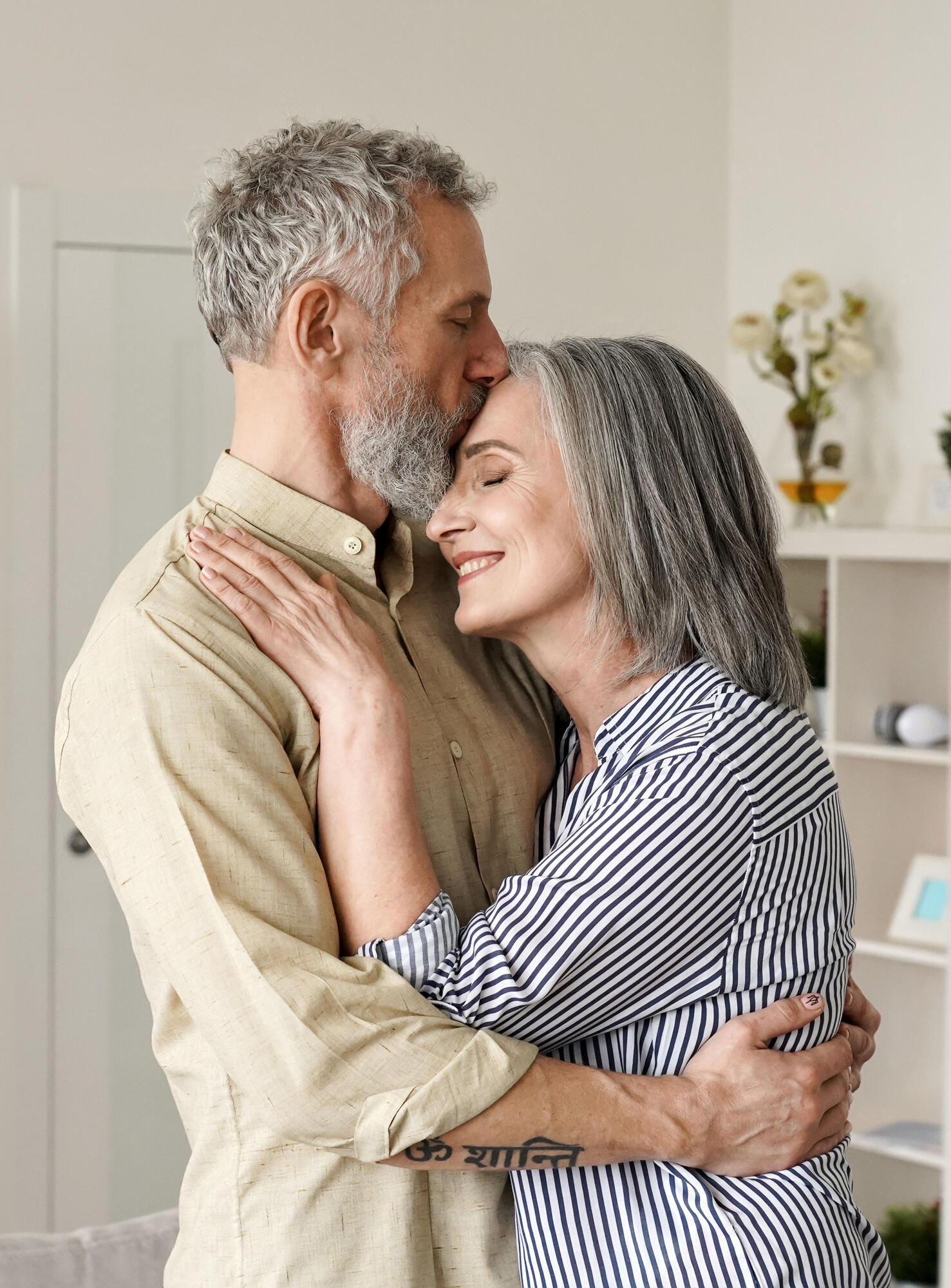 Smiling,Mid,Age,Older,Couple,Hugging,And,Kissing,Standing,At