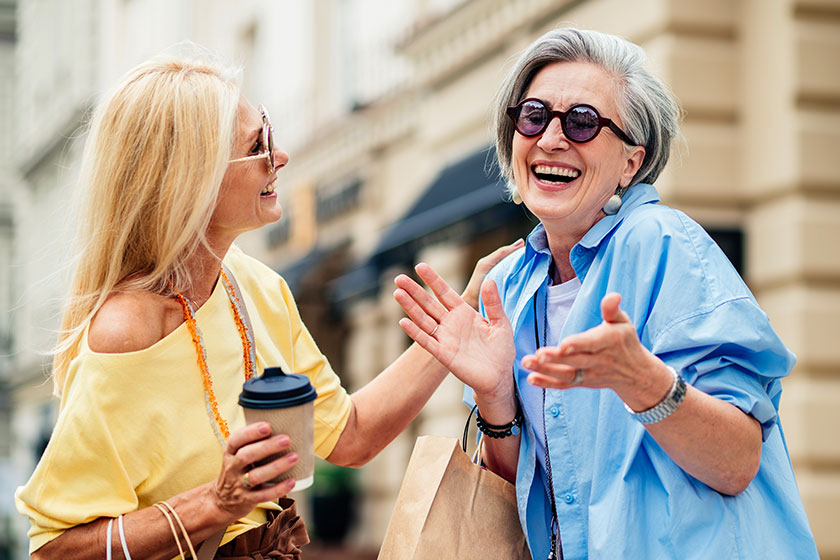 Beautiful happy senior women meeting outdoors shopping city centre pretty