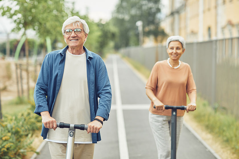 Mature couple riding electric scooters Mature couple riding electric scooters