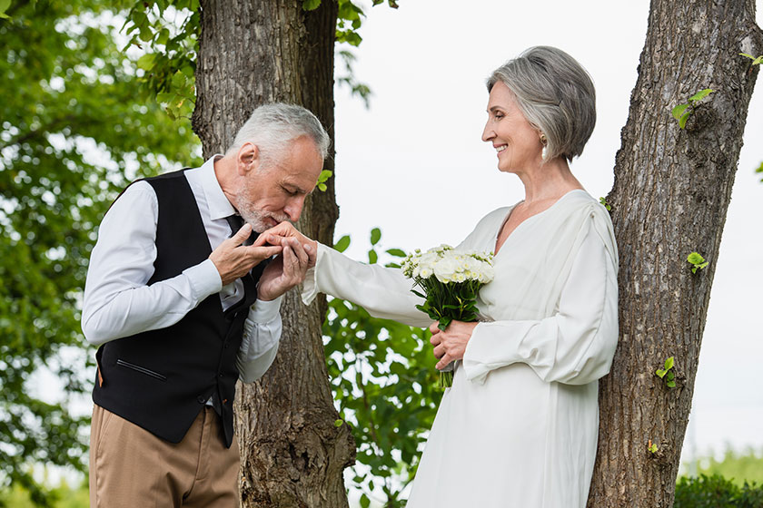 Mature man formal wear kissing hand bride wedding bouquet garden Mature man formal wear kissing hand bride wedding bouquet garden