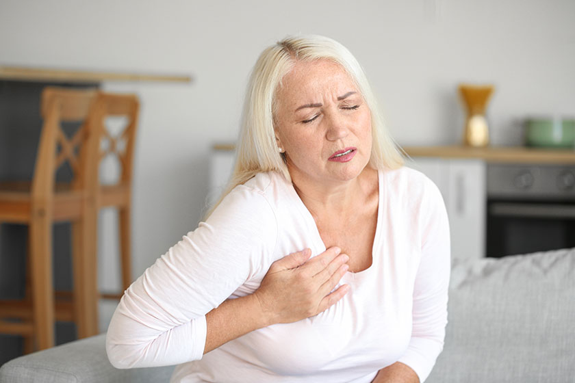 Mature woman suffering breast pain kitchen Mature woman suffering breast pain kitchen