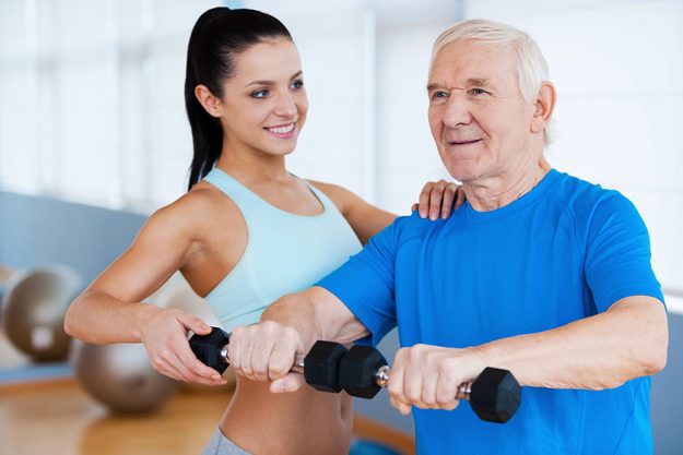 Physical therapist helping senior man with fitness Physical therapist helping senior man with fitness