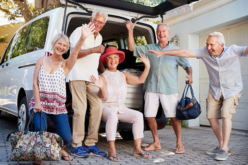 Portrait excited senior friends loading luggage trunk car leave vacation