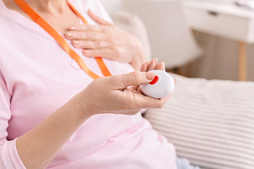 Senior woman feeling heart pain and pressing emergency call button Senior woman feeling heart pain and pressing emergency call button