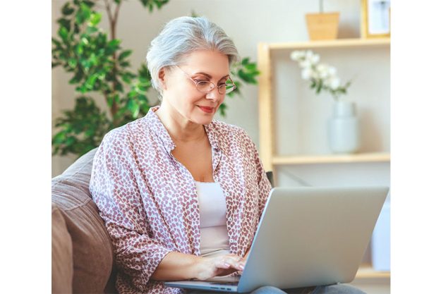 Happy old woman senior working at computer laptop at home Happy old woman senior working at computer laptop at home