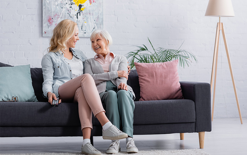 Woman remote controller embracing senior mother