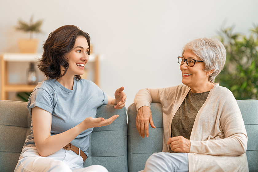 beautiful mother daughter talking smiling while sitting couch