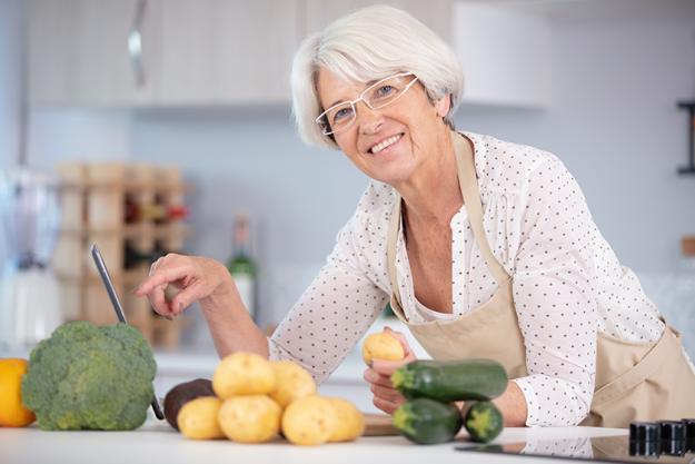 cheerful senior woman standing kitchen