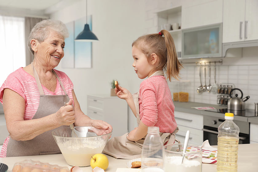 cute girl and her grandmother cooking in kitchen cute girl and her grandmother cooking in kitchen